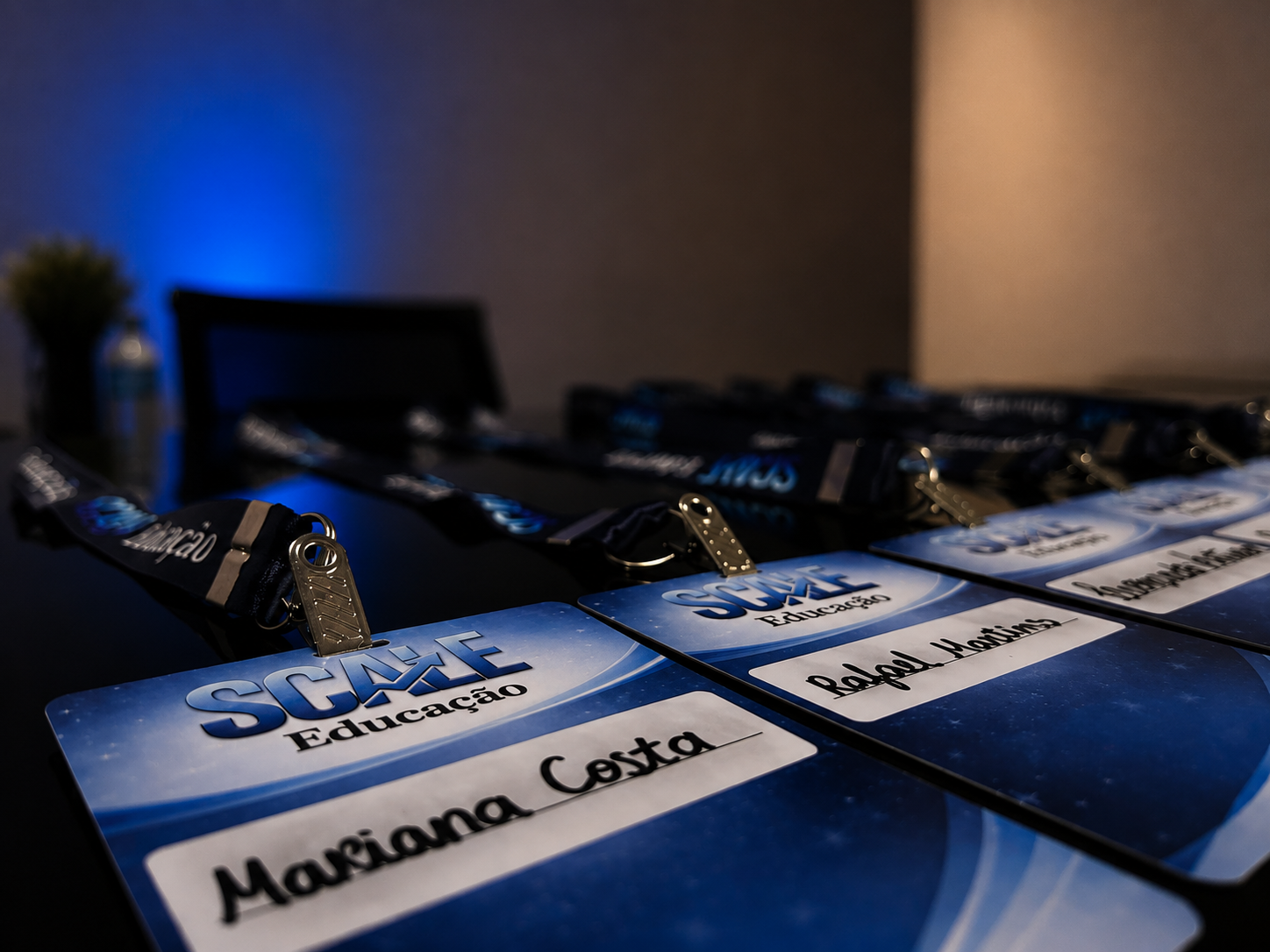 Crachás personalizados da Scale Educação com o nome de cada participante, organizados sobre a mesa antes de um encontro